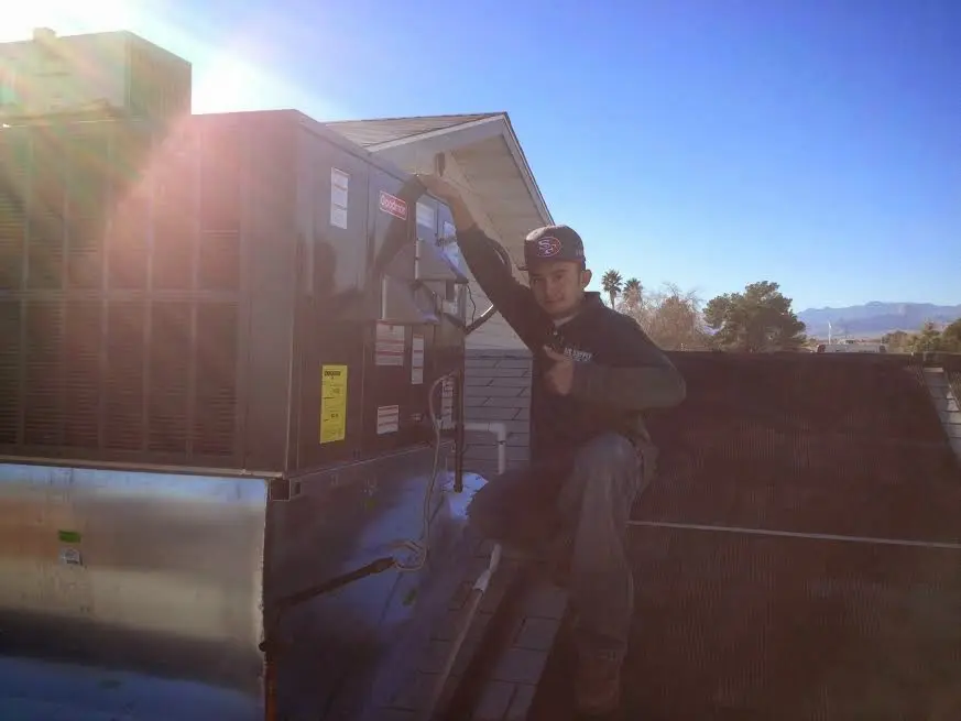 HVAC technician performing AC Tune-Up on a rooftop unit in Bozeman